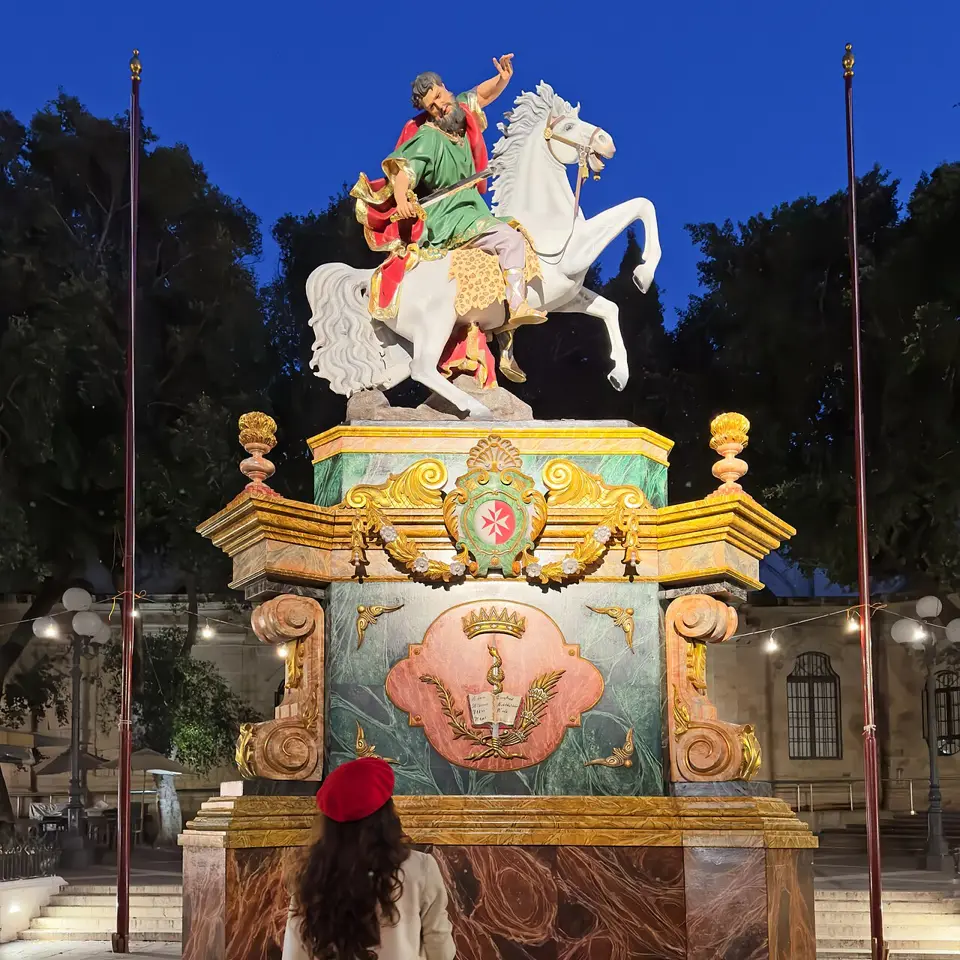 A quiet moment beside the statue of St Paul during the festa.